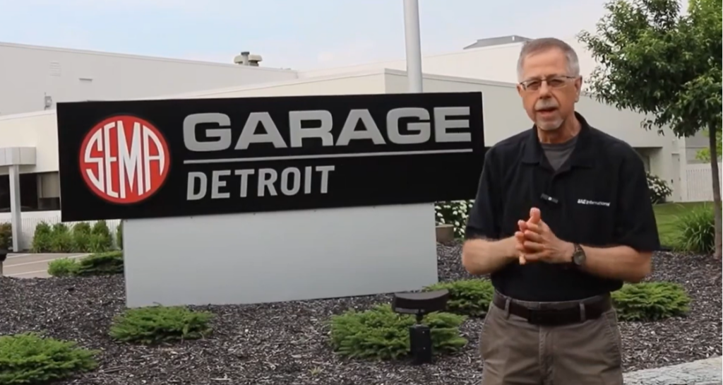 Mark Zachos in front of SEMA Garage Detroit Mark Zachos teaches hands-on workshop on advanced vehicle protocols and cybersecurity at SEMA Garage Detroit
