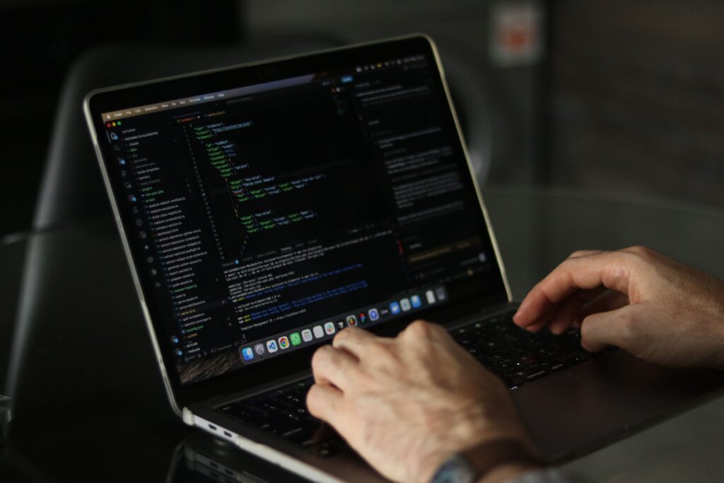 Close-up of hands coding on a laptop. CISA Alerts on Nx Console and Magalodon Supply Chain Compromise